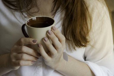 Elinde çay bardağı tutan kadın..