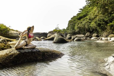 Doğal havuzda kaya yoga güzel model, Trindade, Rio de Janeiro, Brezilya.