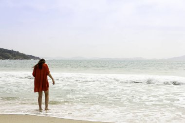 Denize doğru yürüyen ıssız bir sahilde model.