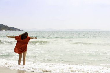 Açık kollu ıssız plajda model.