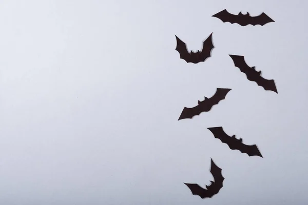 ハロウィンと装飾のコンセプト 灰色の背景を飛んでいる黒い紙のコウモリ — ストック写真