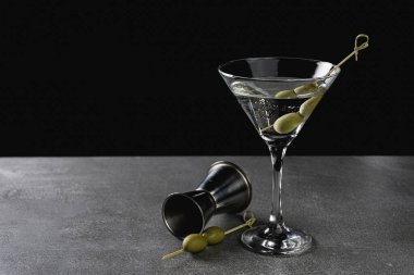 Arkaplanda yeşil zeytinli sek sek martini iç..