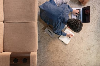 Genç çalışma online webinar podcast izlerken dizüstü bilgisayarda eğitim dersi konferansını dinlerken notlar al.