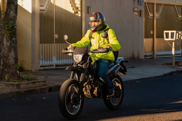 Portrait of motorcycle delivery man riding to his destination.