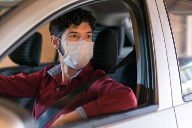 Tıbbi maske takan uygulama sürücüsü.