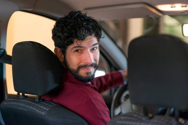 Arabanın camından gülümseyen bir sürücünün portresi. Ehliyet kavramı.