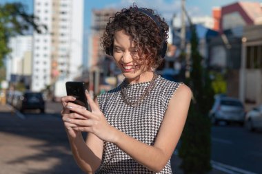 Video araması yapmak için akıllı telefon kullanan kadın.