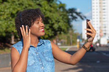 Fotoğraf çekmek için elinde cep telefonu olan genç bir kadın..