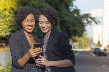 İş kadınları cep telefonuyla mesaj gönderiyor.
