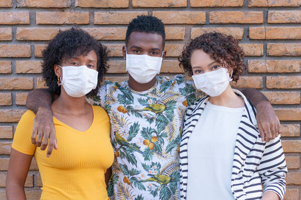 Group of young people looking at camera using protective mask.