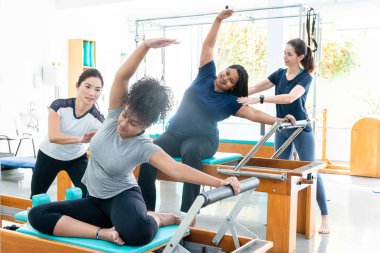 Pilates stüdyosu. Öğrencilere rehberlik eden eğitmenler.