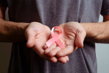 Pembe kurdele tutan adam. Farkındalık kurdelesi.