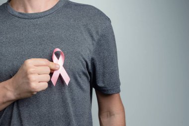 Adam gömleğine pembe kurdele takıyor. Bilinç sembolü.