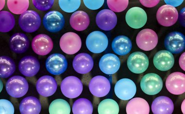 Siyah panel ve renkli balonlar bir sıra deseninde panoda