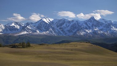 Panorama bir dağ yolda yeşil tepeler ve yüksek karlı dağlar