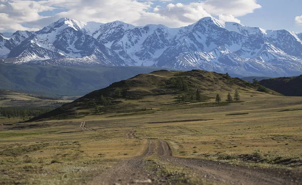 Panorama bir dağ yolda yeşil tepeler ve yüksek karlı dağlar