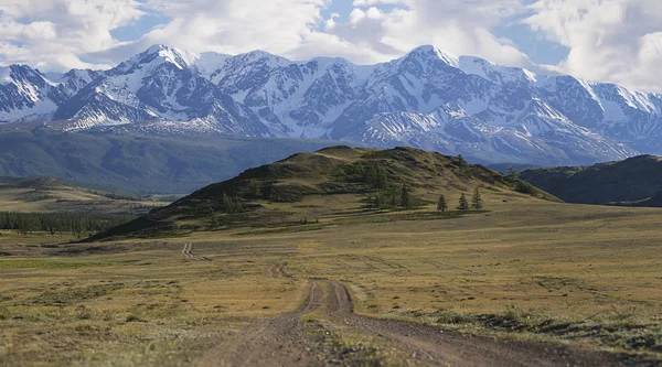 Panorama bir dağ yolda yeşil tepeler ve yüksek karlı dağlar