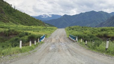 Yol ve dağların Nehri geçip ahşap köprü