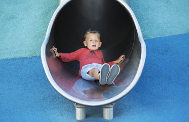 Dört yıllık bir çocuk bir metal hill-trompet oyun alanında sürme