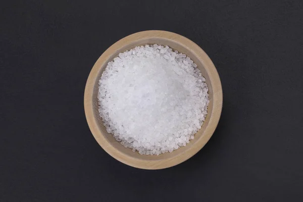天然海水加碘盐在一个小木碗孤立的黑色背景 顶部视图 — 图库照片