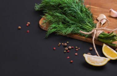 Bir demet taze dereotu bir yay ve baharat ve sarımsak bir kara tahta, üstten görünüm üzerinde karışımı ile bir ip ile sargılı