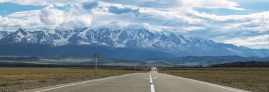 Panorama bir dağ yolda yeşil tepeler ve yüksek karlı dağlar