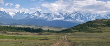 Panorama bir dağ yolda yeşil tepeler ve yüksek karlı dağlar