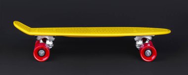 Sarı Kruvazör penny plastboard siyah arka plan üzerinde önden görünüm izole kırmızı tekerlekli
