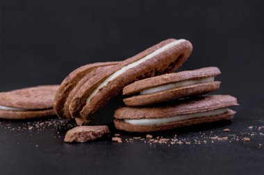 Yakın çekim yan görünüm, siyah bir arka plan doldurarak beyaz Kremalı çikolatalı sandviç kurabiye