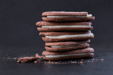 Yakın çekim yan görünüm, siyah bir arka plan doldurarak beyaz Kremalı çikolatalı sandviç kurabiye