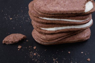 Yakın çekim üstten görünüm, siyah bir arka plan doldurarak beyaz Kremalı çikolatalı sandviç kurabiye