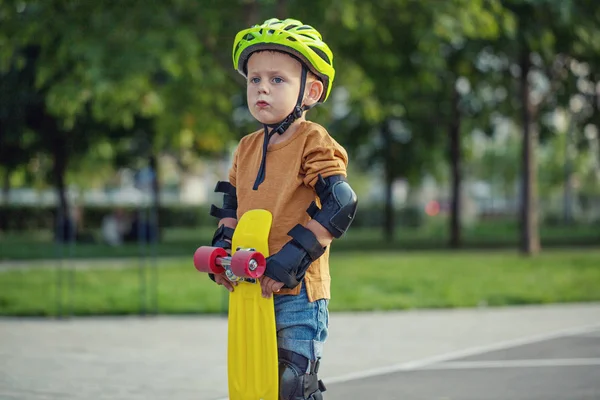 소년은 화창한 공원에 놀이터에 노란색 크루저 Plastboard — 스톡 사진