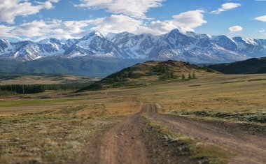 Panorama bir dağ yolda yeşil tepeler ve yüksek karlı dağlar