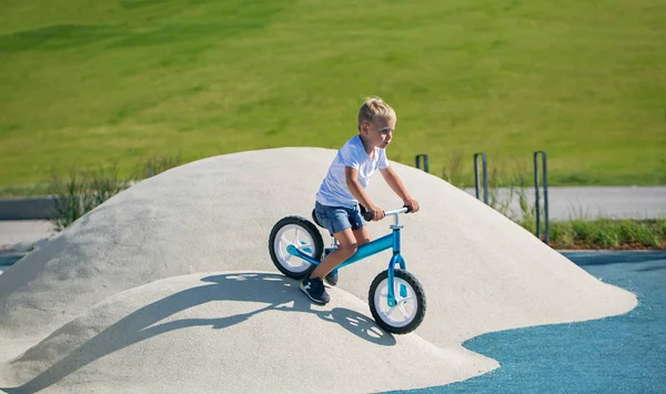 Menino Desfruta Uma Bicicleta Equilíbrio Colinas Artificiais Parque Dia Ensolarado — Fotografia de Stock