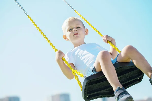 Little Boy Looks Camera Enjoys Swings Playground City Park Sunny — Stock Photo, Image