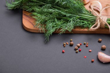 Bir demet taze dereotu bir yay ve baharat ve sarımsak bir kara tahta, üstten görünüm üzerinde karışımı ile bir ip ile sargılı