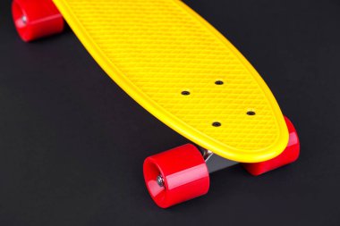 Sarı Kruvazör penny plastboard üstten görünüm, siyah bir arka plan izole kırmızı tekerlekli