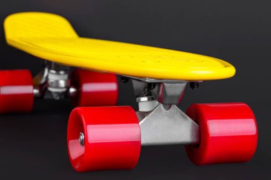 Sarı Kruvazör penny plastboard önden görünüm, siyah bir arka plan izole kırmızı tekerlekli