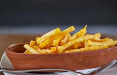 Oval kil tabak patates kızartması ahşap bir tabloda, önden görünüm