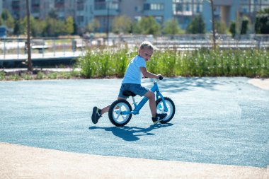 Küçük bir çocuk bir denge bisikleti sahiptir