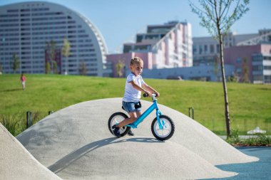 Küçük bir çocuk bir denge bisikleti sahiptir