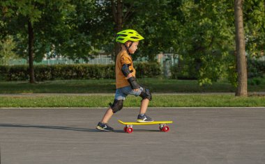 Küçük bir çocuk sarı kruvazör kuruş plastboard sahiptir