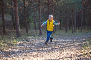 bir orman yolu boyunca çalışan çocuk