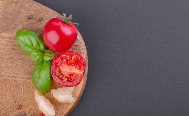 Rigiano parmesan parçaları, kiraz domates ve fesleğen yaprağı