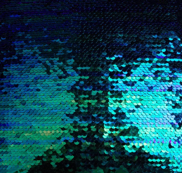 Yeşil, mavi ve mor payetlerin arka planı