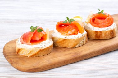 Beyaz ahşap bir masada mini somon sandviçi.