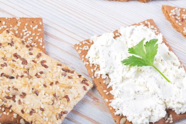 Tahta beyaz masada ricotta soslu susamlı kraker.