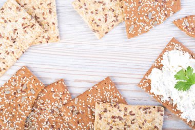 Tahta beyaz masada ricotta soslu susamlı kraker.