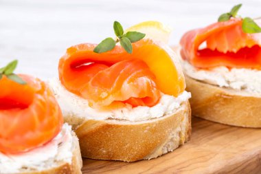 Beyaz ahşap bir masada mini somon sandviçi.