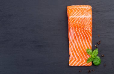 Siyah ahşap bir masada çiğ taze somon.